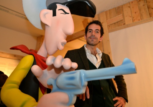 Jul pose a cote de la figurine geante du personnage de Lucky Luke lors d'une exposition consacree a son createur, Morris, dans le cadre du festival d'Angouleme, le 28 janvier 2016