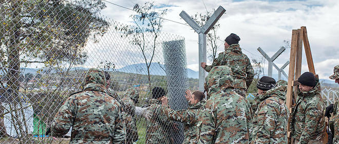 L'armee mecedonienne erige un grillage a la frontiere avec la Grece le 28 novembre. Les ONG craignent que les passeurs profitent de ces obstacles dresses sur la route des migrants. 