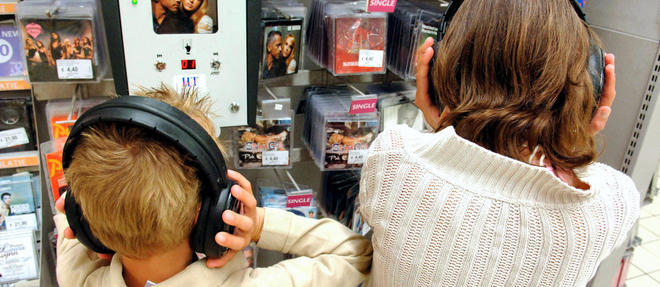 Enfants ecoutant de la musique dans le rayon multimedia d'un supermarche / Children listening to music in the multimedia department of a supermarket. MODEL RELEASED