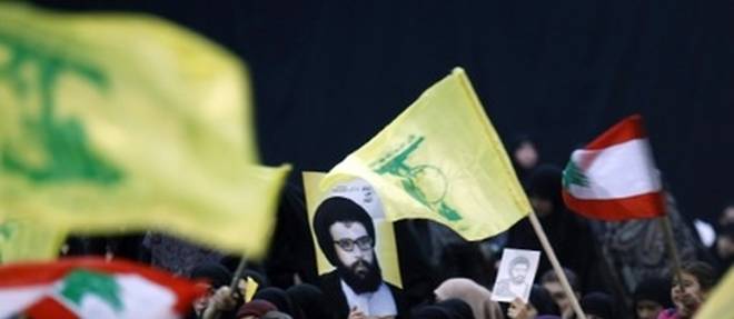 Des partisans brandissent des drapeaux du Liban et du Hezbollah ainsi qu'une affiche de l'ancien leader du mouvement chiite libanais Abbas Moussaoui, le 16 fevrier 2016 a Beyrouth