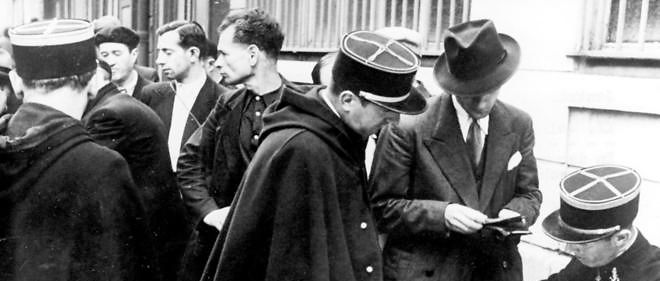 Des policiers francais controlent les papiers de Juifs arretes en aout 1941.
