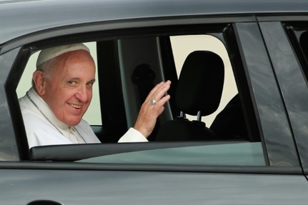 Assis a l'arriere de la Fiat, le pape Francois salue a son arrivee a Andrews Air Force Base aux Etats-Unis le 22 septembre 2015 