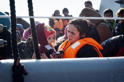 Une femme et son enfant arrivent a bord d'un bateau des gardes-cotes grecs au port de Mytilene, sur l'ile grecque de Lesbos, le 29 mars 2016