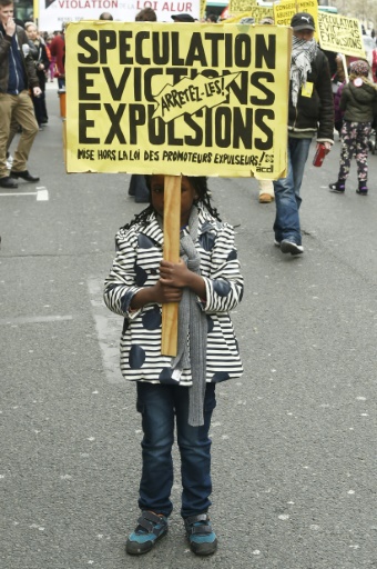 Une enfant brandit une pancarte lors de la manifestation contre les expulsions après la fin de la trêve hivernale, à Paris le 2 avril 2016 © DOMINIQUE FAGET AFP