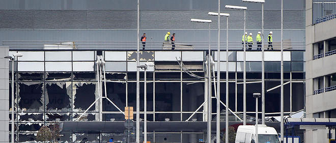 Des ouvriers renforcent le toit de la facade endommagee de l'eaeroport de Zaventem, peu apres les attentats.