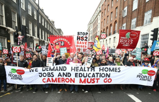 Des manifestants avec une banderole demandant "santé, logement, emploi et éducation" et le départ du Premier ministre conservateur David Cameron  lors du rassemblement anti-austérité à Londres le 16 avril 2016 © JUSTIN TALLIS AFP