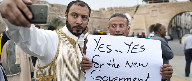 A Tripoli, en avril 2016, sur la place des Martyrs, lors d'un rassemblement, deux  manifestants se prennent en photo en affichant leur soutien au nouveau gouvernement.