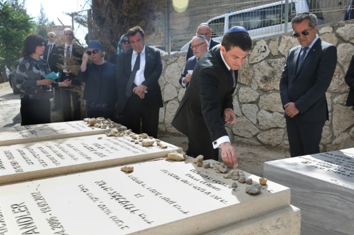 Manuel Valls (2e à d) dépose des cailloux sur les tombes de victimes françaises d'actes antisémites au grand cimetière Givat Shaul en Israël le 23 mai 2016 © MENAHEM KAHANA AFP