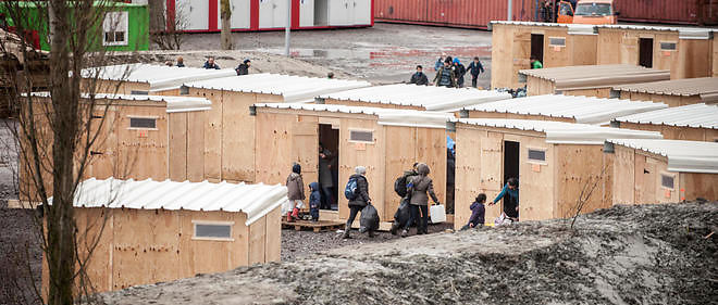 Camp de la Liniere a Grande-Synthe. Des migrants a l'entree des cabanes en bois financees par la ville et MSF, le 7 mars 2016.
