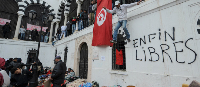 Des Tunisiens exultent pendant la revolution tunisienne en fevrier 2011.