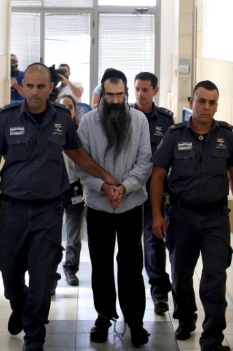 Yishaï Shlissel encadré par des policiers, lors de son arrivée au tribunal à Jérusalem, le 26 juin 2016 © GALI TIBBON AFP