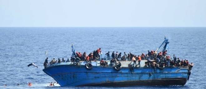 Photo fournie le 25 mai 2016 par la Marine italienne montrant un bateau de migrants sur le point de faire naufrage au large de la cote libyenne