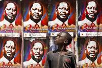 Un jeune garcon kenyan devant les affiches de campagne du candidat de l'opposition Raila Odinga sur le mur pres d'un bureau de vote. 
