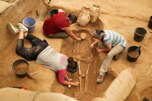 Une équipe d'archéologues étrangers sur le site du premier cimetière philistin jamais découvert à Ashkelon en Israël, le 28 juin 2016 © MENAHEM KAHANA AFP