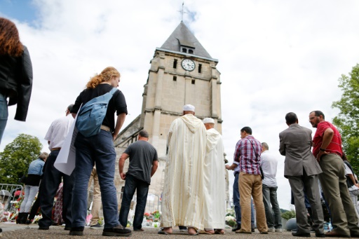 Des musulmans respectent une minute de silence devant l'église de Saint-Etienne-du-Rouvray le 29 juillet 2016 © CHARLY TRIBALLEAU AFP