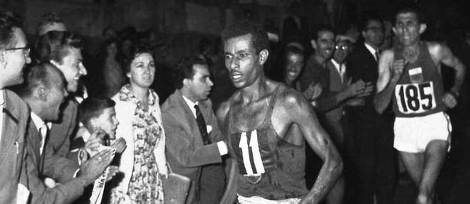Abeba Bikila lors de sa course victorieuse du Marathon olympique de Rome le 10 septembre 1960. Il est pieds nus et mene la course devant le Marocain Rhadi Ben Abdesselam.