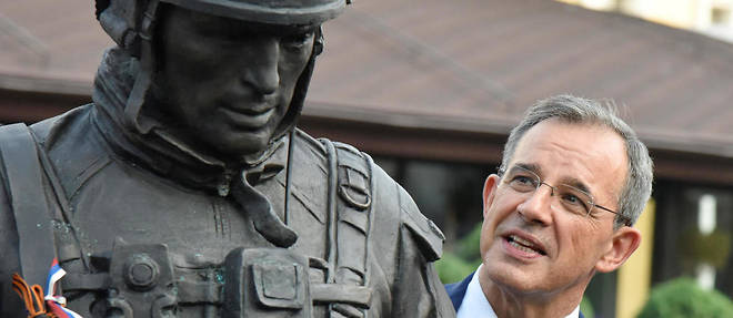 Thierry Mariani posant avec une statue d'un militaire russe. 