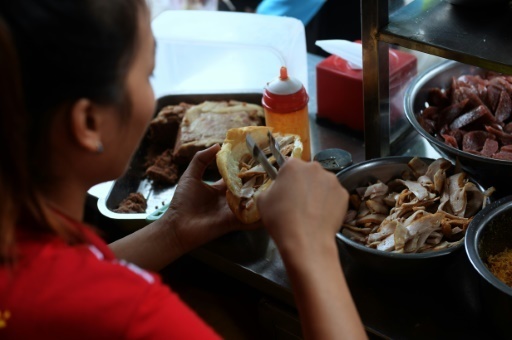 Preparaion d'un sandwich appele banh-mi a Hanoi, le 31 aout 2016