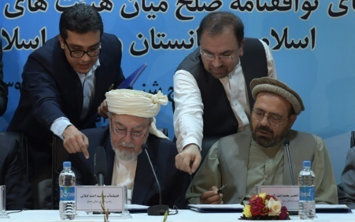 Le representant du Haut Conseil pour la paix, Pir Sayed Ahmed Gailani (g), et le representant du chef de guerre Gulbuddin Hekmatyar signent un accord de paix, le 22 septembre 2016 a Kaboul, en Afghanistan