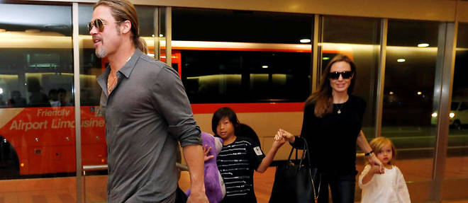 Knox (derriere son pere), Vivienne et Pax debarquent avec leurs parents a Tokyo le 28 juillet 2013.