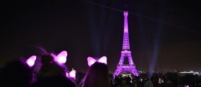 Des touristes posent devant la tour Eiffel en rose dans le cadre de la campagne pour sensibiliser au cancer du sein, le 26 septembre 2016