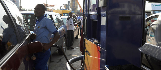Un employe fait le plein pour une voiture dans une station-service de Lagos, au Nigeria.