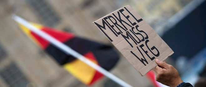 Une foule xenophobe a accueilli la chanceliere allemande Angela Markel a Dresde avec des sifflets et des pancartes "Merkel doit partir".