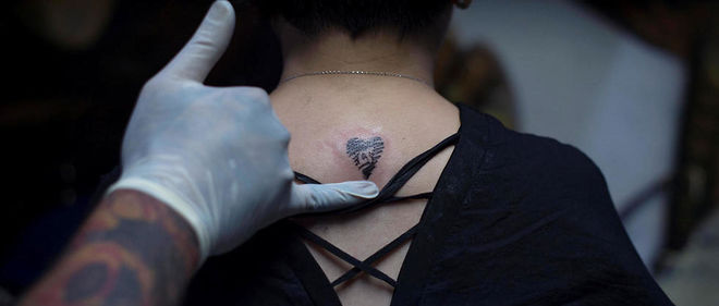Une personne se fait tatouer le symbole du roi thailandais decede.