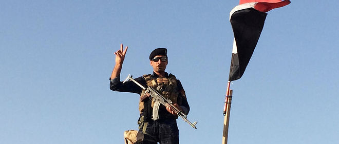 Un membre des forces de police federales irakiennes monte la garde sur un talus qui protege la base militaire de Qayyarah, a 70 km de Mossoul.