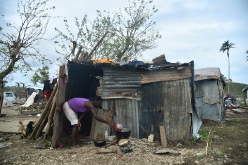 Gislen prépare un repas à l'extérieur de sa cabane, le 22 octobre 2016, dans la banlieue de Jérémie, commune de Haïti, dévastée après le passage de l'ouragan Matthew © HECTOR RETAMAL AFP