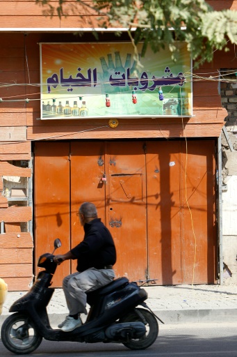 Un Irakien passe devant la porte fermée d'un magasin vendant de l'alcool à Bagdad le 23 octobre 2016  © SABAH ARAR AFP