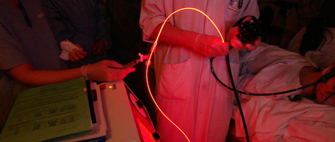 Une fibre lumineuse, equipee d'une diode laser, produit une lumiere rouge utilisee pour le traitement d'une maladie dermatologique. 