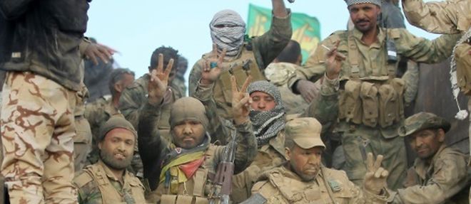 Des combattants chiites de la coalition Hachd  al-Chaabi font le signe de la victoire a l'arrivee dans un village au sud de Mossoul, le 31 octobre 2016