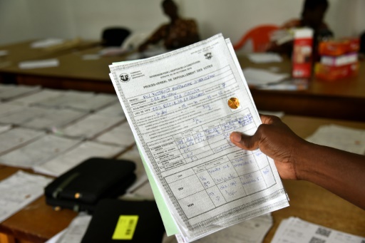 Un employé de la Commission électorale indépendante montre un document concernant les résultats du scrutin le 31 octobre 2016 à Abidjan © Sia KAMBOU AFP