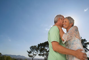 Older couple hugging on terrace. ©Britt Erlanson