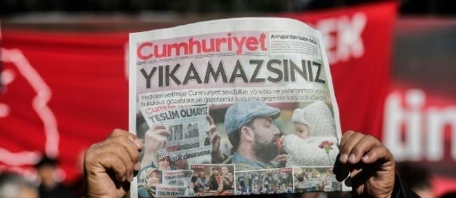 Un manifestant brandit un exemplaire du quotidien d'opposition "Cumhuriyet" devant le siege du journal a Istanbul le 2 novembre 2016
