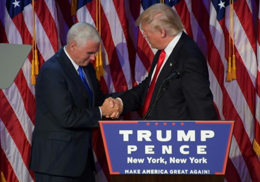 Donald Trump (d) serre la main de son vice président Mike Pence, le 9 novembre 2016 à New York, après avoir été désigné comme le nouveau président américain © JIM WATSON AFP