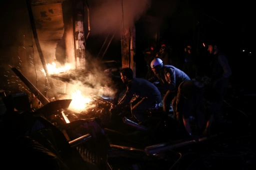 Des "Casques blancs" syriens tentent d'éteindre un incendie après des frappes aériennes du régime, le 17 novembre 2016 à Douma © Sameer Al-Doumy AFP