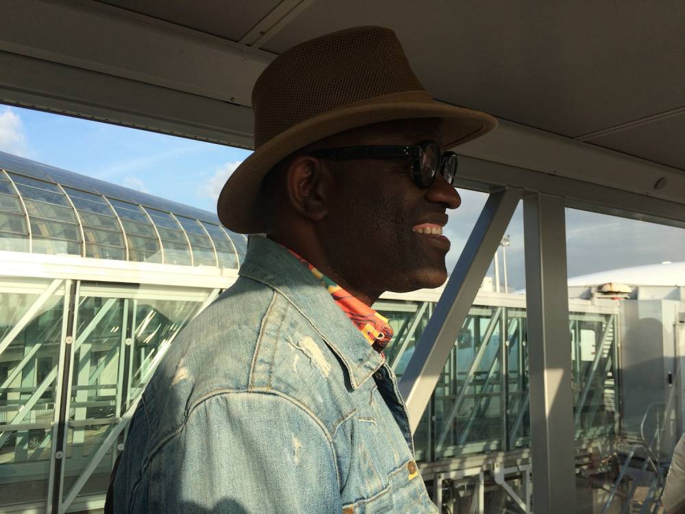 L'écrivain Alain Mabanckou dans l’avion qui l’emmène à Dakar, le 27 octobre dernier, pour les Ateliers de la pensée. ©  Valérie Marin la Meslée