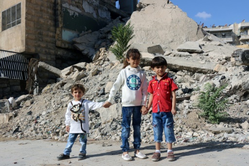 Bana (c) et ses frères devant des bâtiments détruits, le 10 octobre 2016 à Alep © THAER MOHAMMED AFP/Archives