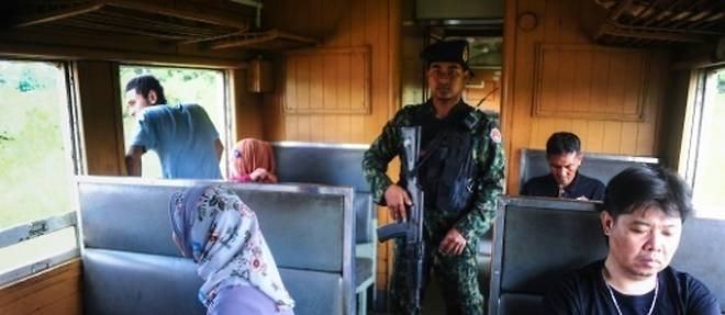 Un soldat au milieu des passagers du train de 12H33, le 21 novembre 2016 a Narathiwat dans l'extreme sud de la Thailande