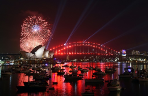 Des feux d'artifice familiaux illuminent le ciel au-dessus de l'Opéra de Sydney en Australie, avant le feu d'artifice officiel, le 31 décembre 2016 © SAEED KHAN AFP