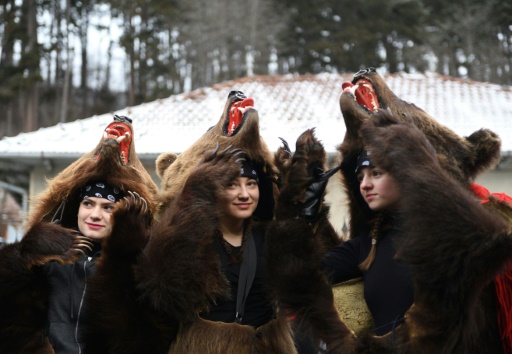 Des roumains vêtus de peaux d'ours dansent dans les rues de Comanesti, le 30 décembre 2016 lors d'un défilé pour chasser les mauvais esprits de l'année écoulée © DANIEL MIHAILESCU AFP