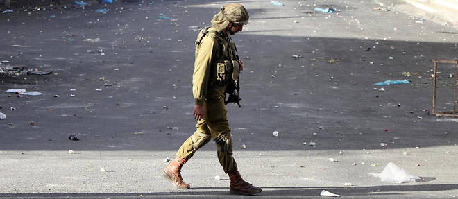 Un soldat israelien dans les rues d'Hebron apres des emeutes.