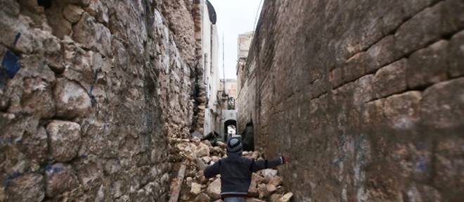 Un enfant se fraye un chemin a travers les ruines de batiments a Alep, le 17 decembre 2016.