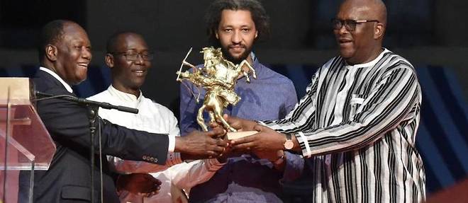 Alain Gomis (au centre) recoit son prix des mains des presidents ivoirien et burkinabe le 4 mars 2017 a Ouagadougou, au Burkina.