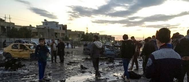 Des irakiens autour de la zone ou une voiture piegee a explose, a Bagdad le 16 fevrier 2017