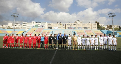 L'équipe de foot féminine palestinienne (en rouge), avant un match de qualification contre la Thaïlande, le 3 avril 2017 à Al-Ram, en Cisjordanie © ABBAS MOMANI AFP