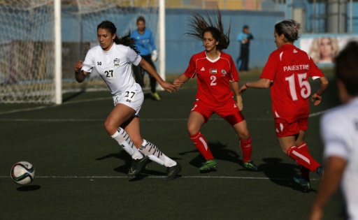 L'équipe de foot féminine palestinienne (en rouge), lors d'un match de qualification contre la Thaïlande, le 3 avril 2017 à Al-Ram, en Cisjordanie © ABBAS MOMANI AFP