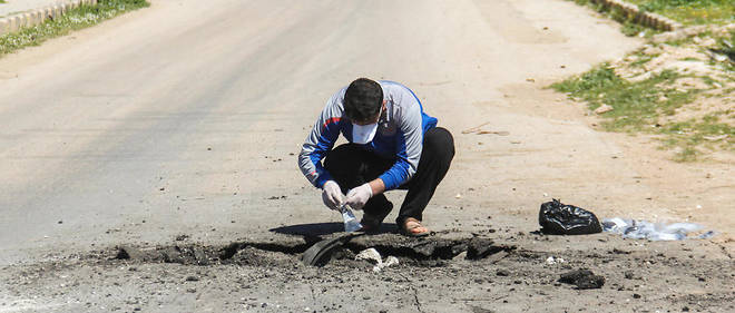 Un homme collecte des echantillons sur le site de l'attaque chimique qui a eu lieu dans la ville de Khan Sheikhoun, en Syrie, le 5 avril. 
 